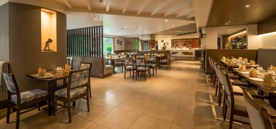 City Park Hotel restaurant: A spacious hall filled with rows of chairs, offering one of the best 5-star hotel restaurant in Delhi