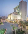 Exterior view of Hotel City Park Pitampura with illuminated modern architecture, landscaped entrance, and decorative lighting at dusk.
